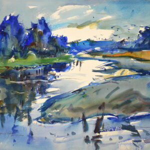 A winding estuary channel reflects a bright sky between banks of green grass and tan mudflats. Deep blue trees cluster along the shoreline beneath a blue sky with white clouds, and dark posts break the still water in the foreground.