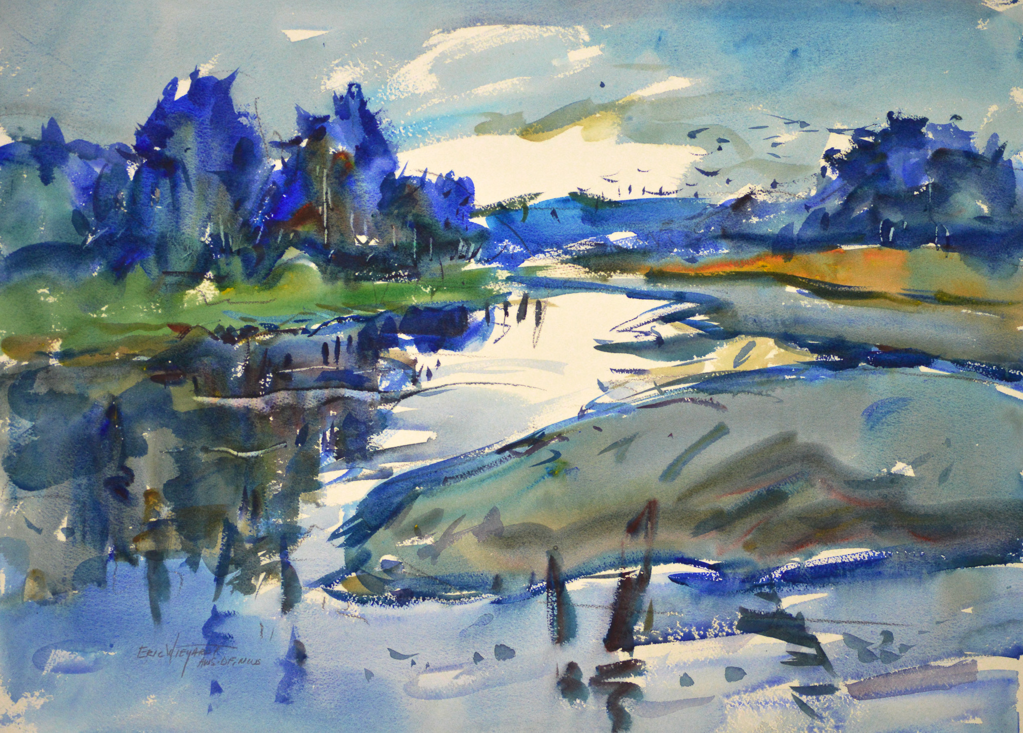 A winding estuary channel reflects a bright sky between banks of green grass and tan mudflats. Deep blue trees cluster along the shoreline beneath a blue sky with white clouds, and dark posts break the still water in the foreground.