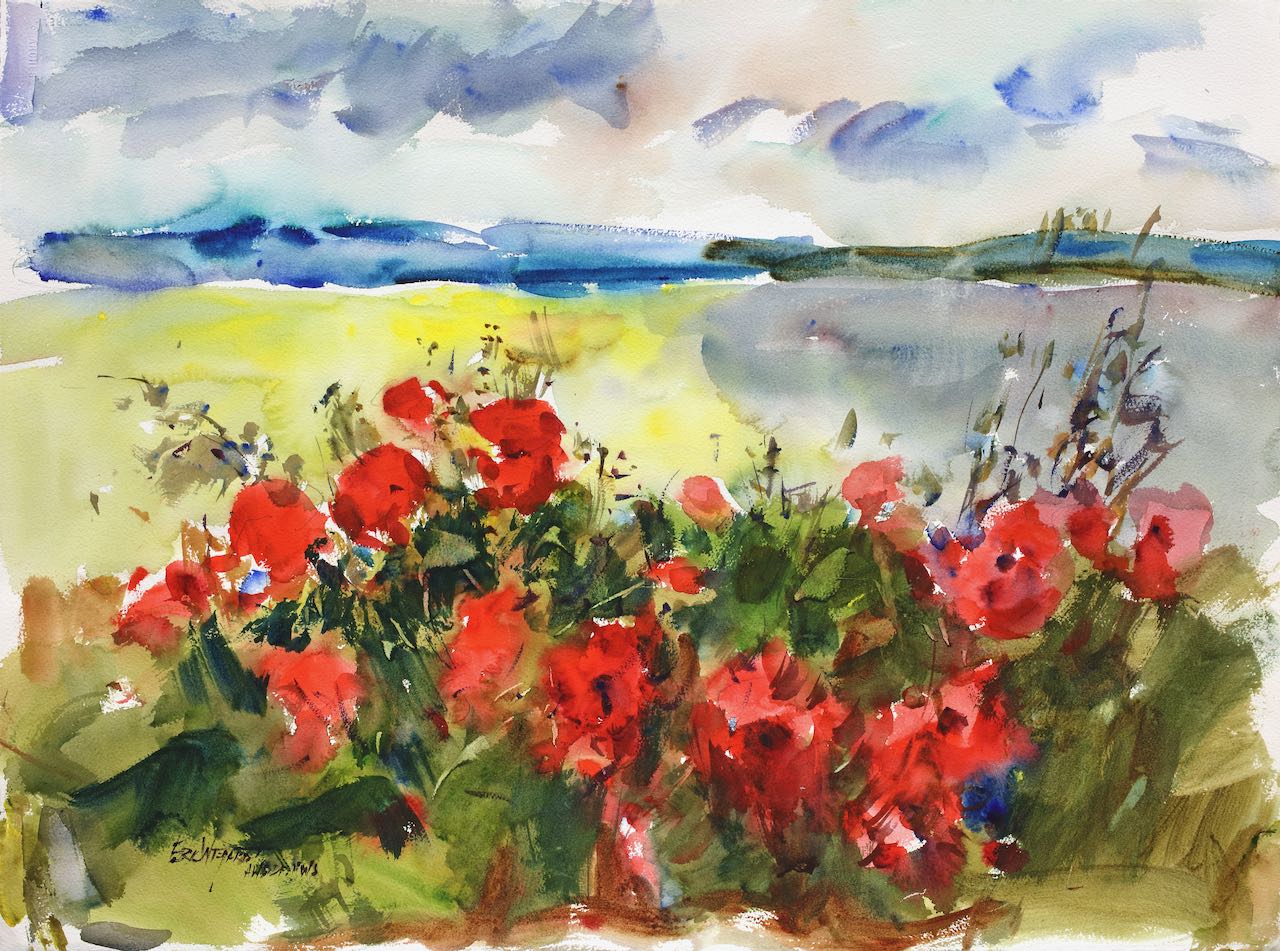 Watercolor landscape with vivid red poppies and green foliage filling the lower foreground. Behind them, a bright yellow-green field opens into a band of deep blue water, with a dramatic gray and peach cloud-filled sky above.