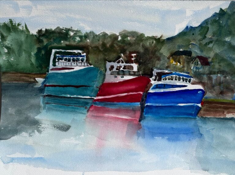 Teal, red and blue boats in water with trees behind reflecting in the water.