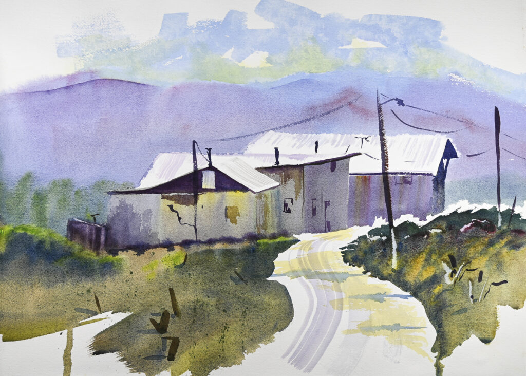 Truchas Vista, original watercolor painting of three white buildings. There is a white road running in front and green grass covering the ground around and purple hills behind.
